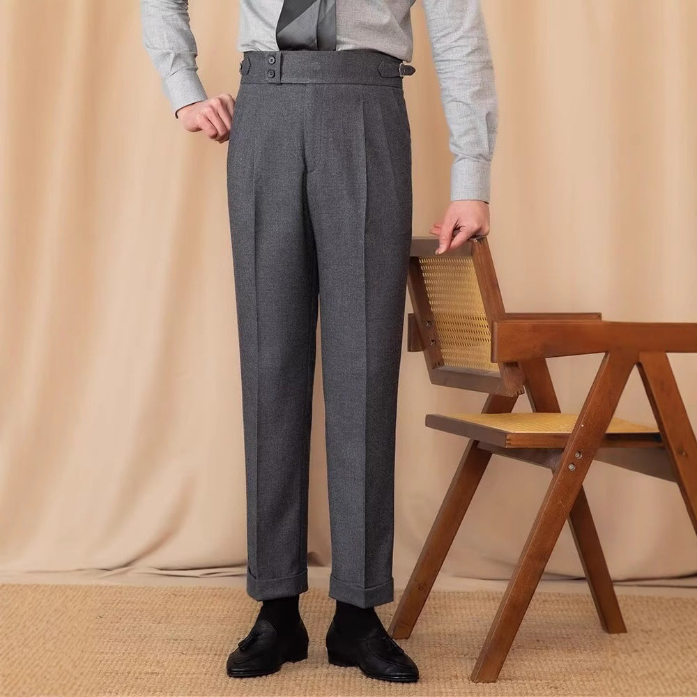 Pantaloni eleganti grigi da uomo, abbinati a camicia chiara e scarpe nere, accanto a sedia in legno. Moda maschile classica e sofisticata.