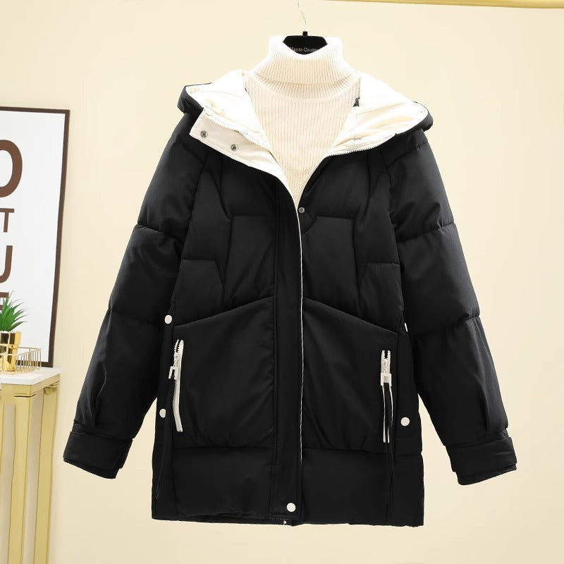 Giacca invernale nera imbottita con cappuccio, zip frontali e tasche, su sfondo chiaro. Moda donna, abbigliamento caldo, stile casual.
