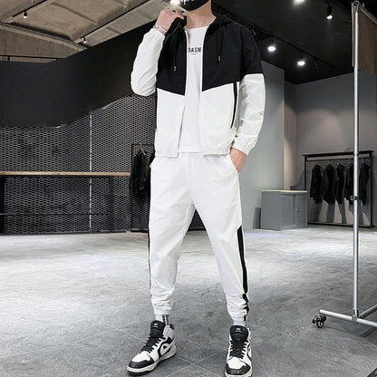 Uomo in tuta sportiva bianca e nera, scarpe da ginnastica, in un negozio di abbigliamento moderno. Stile casual, moda maschile, abbigliamento sportivo.