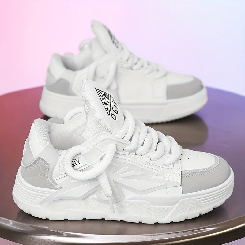 Scarpe da ginnastica bianche e grigie su tavolo, design moderno, suola spessa, lacci robusti, logo visibile. Scarpe sportive eleganti e alla moda.
