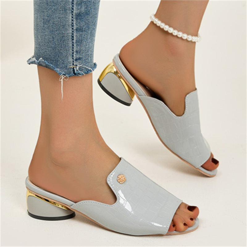 Sandali donna eleganti in pelle bianca con tacco basso dorato, indossati con jeans strappati alla caviglia e cavigliera di perle.