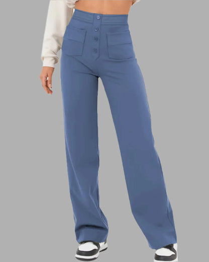 Pantaloni a vita alta blu, larghi, con tasche frontali e bottoni, indossati con sneakers bianche e nere. Moda casual donna, abbigliamento trendy.