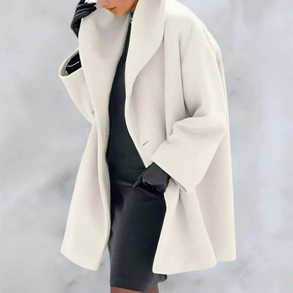 Donna con cappotto bianco elegante, abito nero e guanti in pelle. Moda invernale chic, stile sofisticato. Sfondo grigio chiaro.