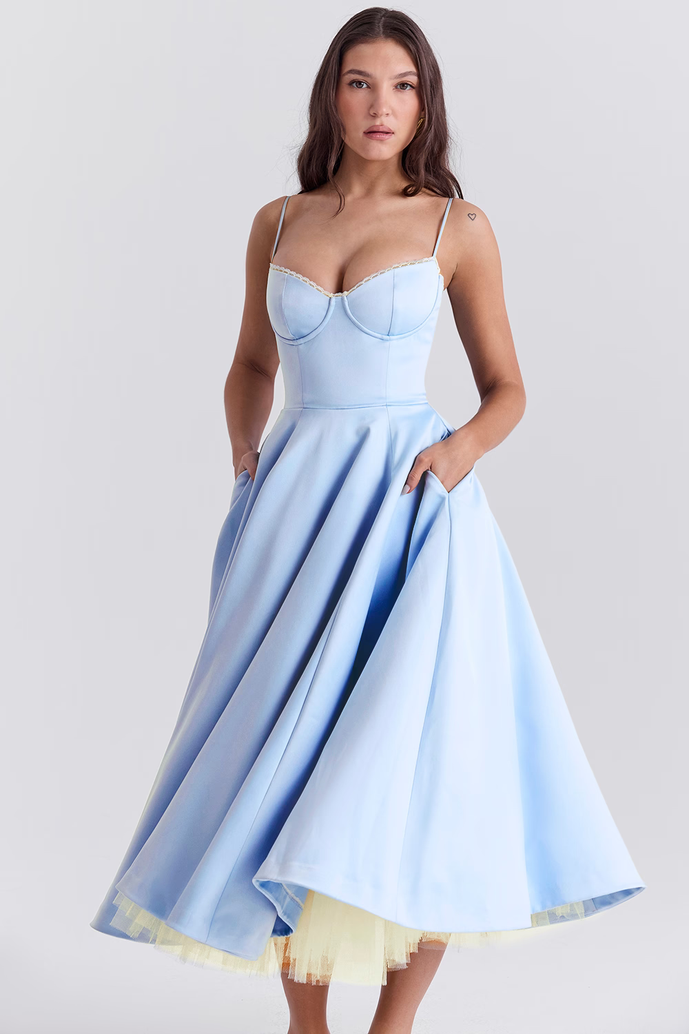 Abito elegante azzurro con spalline sottili e gonna ampia, indossato da una modella. Perfetto per eventi formali e cerimonie.