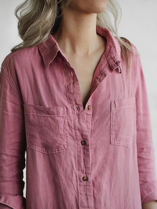 Camicia rosa da donna in cotone, maniche lunghe, con tasche frontali e bottoni, indossata da una persona con capelli biondi.