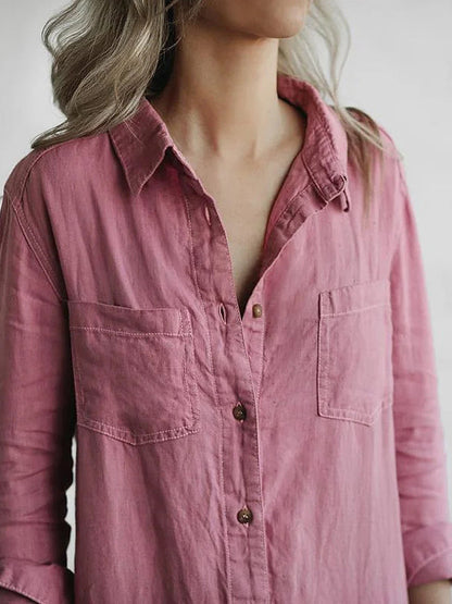 Camicia rosa da donna in cotone, maniche lunghe, con tasche frontali e bottoni, indossata da una persona con capelli biondi.
