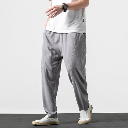Uomo con pantaloni grigi larghi, t-shirt bianca e scarpe casual. Moda maschile, abbigliamento estivo, stile casual elegante.