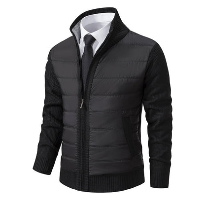 Giacca uomo elegante nera, imbottita, con maniche lavorate a maglia, zip frontale, colletto alto, abbinata a camicia bianca e cravatta nera.