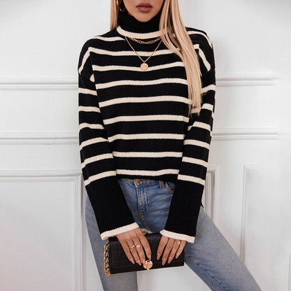 Donna con maglione a righe bianche e nere, jeans, collana dorata e borsa nera. Moda autunnale, stile casual chic, tendenze abbigliamento femminile.