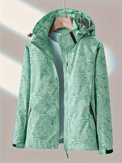 Giacca impermeabile verde con cappuccio, motivo floreale, appesa su gruccia. Abbigliamento outdoor, moda donna, tessuto tecnico.
