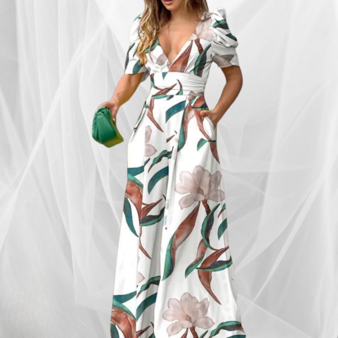 Abito lungo estivo bianco con stampa floreale, maniche a sbuffo e scollo a V, accessoriato con borsa verde. Moda donna elegante e trendy.