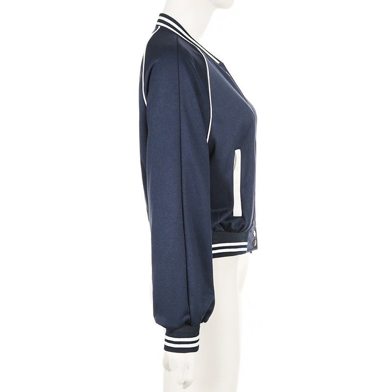 Giacca bomber blu scuro da donna, maniche lunghe, dettagli a righe bianche su colletto e polsini, stile casual, moda autunnale.