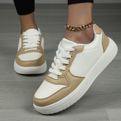Scarpe da ginnastica bianche e beige su pavimento in legno, indossate con cavigliera dorata. Design moderno, casual e alla moda.