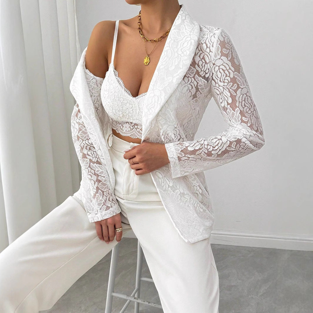 Donna in abito elegante bianco, giacca di pizzo e top in pizzo, pantaloni a vita alta, collana dorata, moda femminile chic, stile moderno.