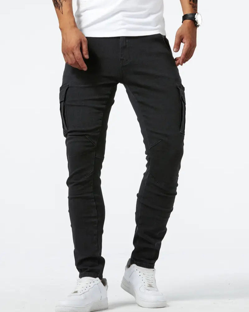 Jeans cargo neri da uomo, vestibilità slim, tasche laterali, abbinati a scarpe da ginnastica bianche. Moda casual maschile.