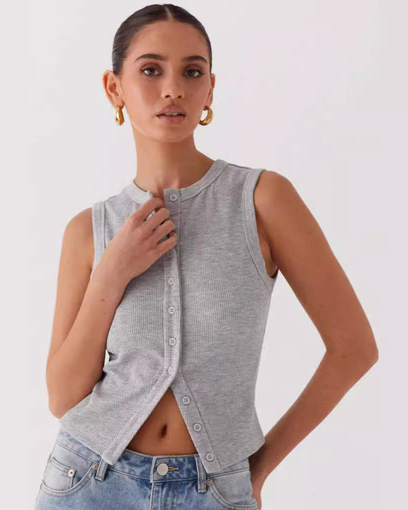 Modella indossa top grigio senza maniche con bottoni, abbinato a jeans blu chiaro. Stile casual, moda donna, abbigliamento estivo.