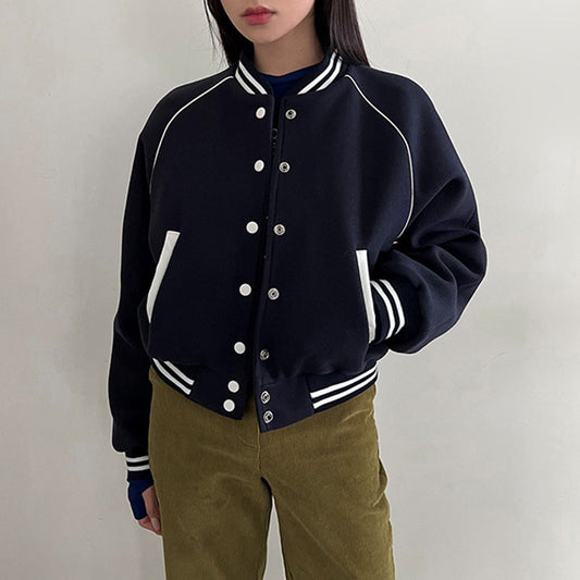 Giacca bomber nera con bottoni, dettagli bianchi e tasche, indossata da una persona. Stile casual, moda autunnale, abbigliamento trendy.