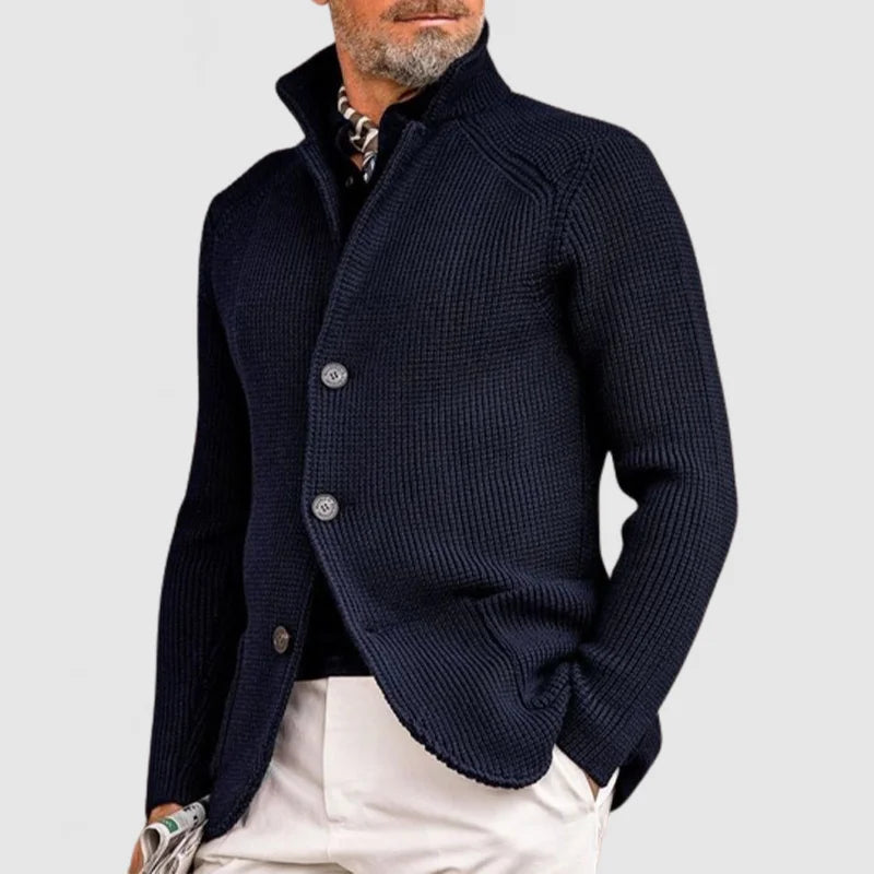Giacca cardigan uomo blu scuro elegante, maglia a coste, tre bottoni, abbinata a pantaloni chiari. Stile casual chic, moda maschile autunnale.