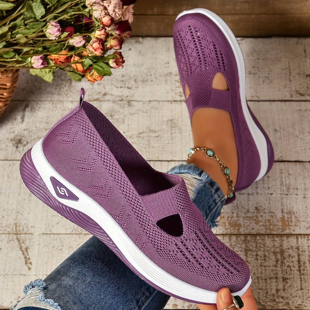 Scarpe da donna viola in maglia traspirante, suola bianca, indossate con jeans. Design casual, comode per passeggiate e attività quotidiane.