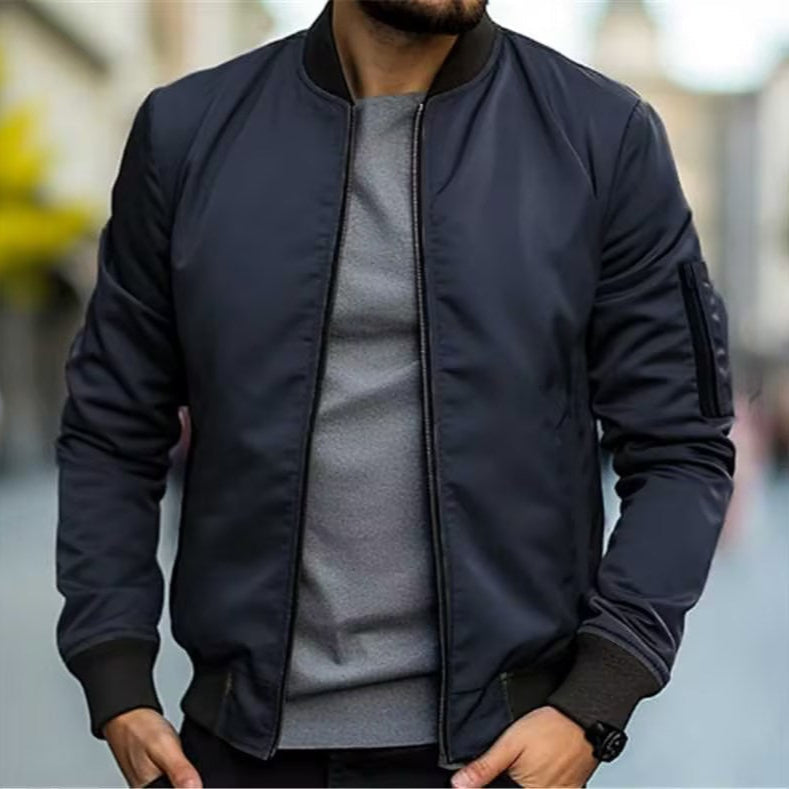 Giacca bomber uomo blu scuro, stile casual, indossata su maglia grigia. Moda maschile autunnale, abbigliamento urbano trendy.