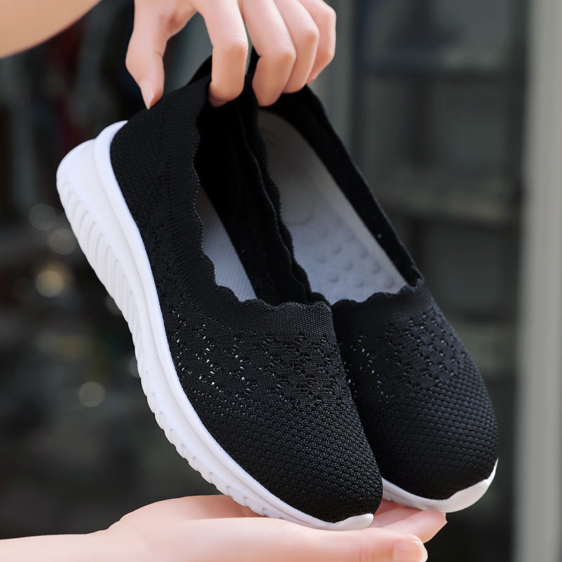 Scarpe da ginnastica nere in tessuto traspirante con suola bianca antiscivolo, design leggero e confortevole, ideali per sport e tempo libero.
