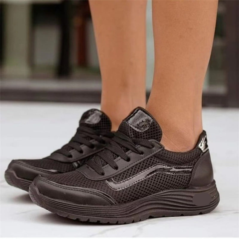 Scarpe da ginnastica nere da donna, design moderno con suola spessa e dettagli in rete, ideali per sport e tempo libero.