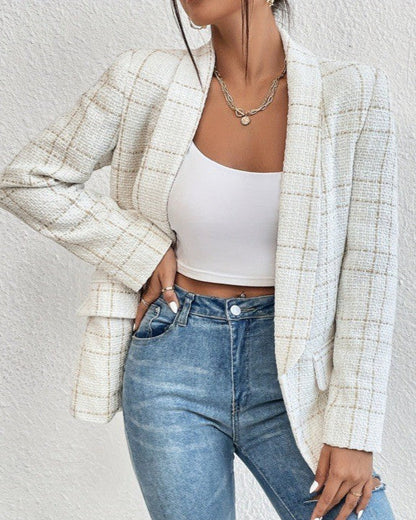 Donna con blazer a quadri bianco, top bianco e jeans. Moda femminile elegante, abbigliamento casual chic, stile contemporaneo.