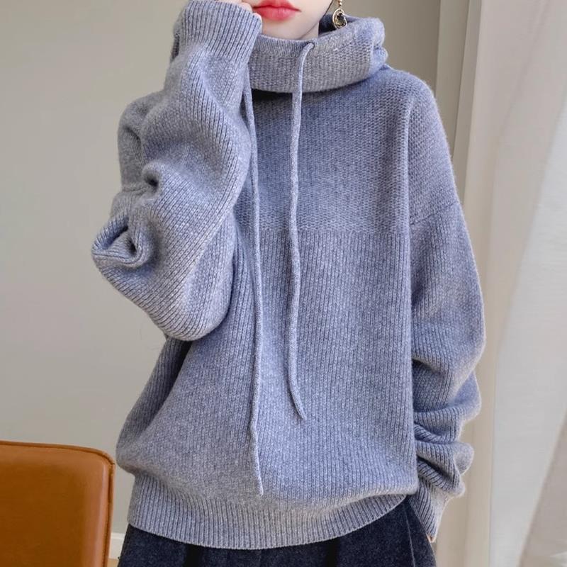 Maglione grigio invernale con cappuccio, morbido e caldo, indossato da una persona. Stile casual, perfetto per moda autunnale e invernale.