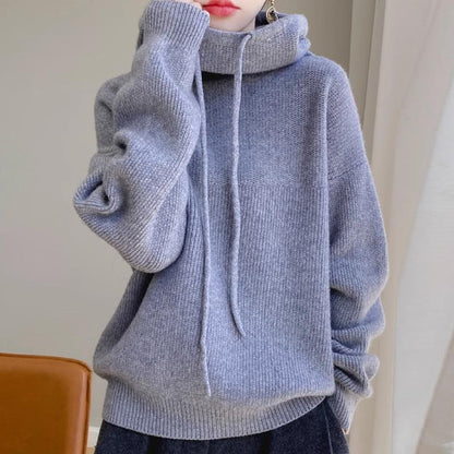 Maglione grigio invernale con cappuccio, morbido e caldo, indossato da una persona. Stile casual, perfetto per moda autunnale e invernale.
