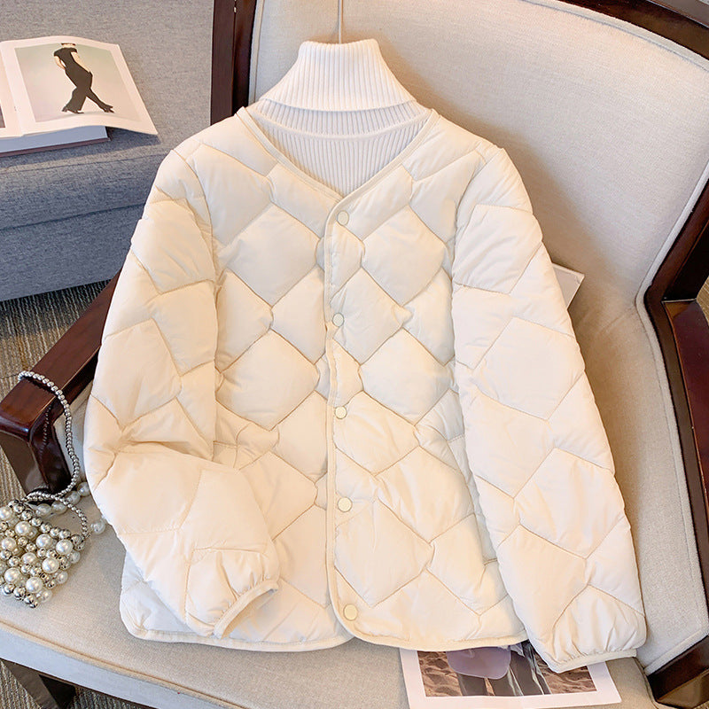 Giacca trapuntata bianca su sedia, design elegante e moderno, perfetta per l'inverno. Moda donna, abbigliamento caldo e confortevole.