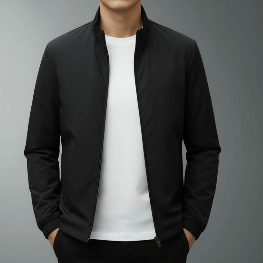 Giacca nera da uomo su sfondo grigio, indossata sopra una maglietta bianca. Moda maschile elegante, abbigliamento casual autunnale.