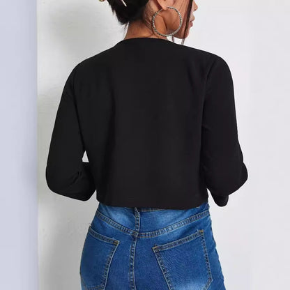 Donna di spalle con giacca nera e jeans blu, orecchini a cerchio grandi. Moda casual femminile, abbigliamento trendy, stile urbano.