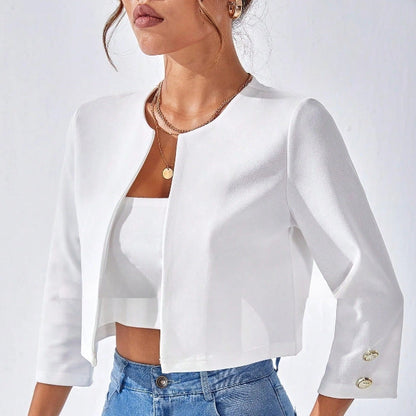 Donna con giacca bianca elegante, top corto e jeans. Moda femminile, abbigliamento casual chic, stile moderno.
