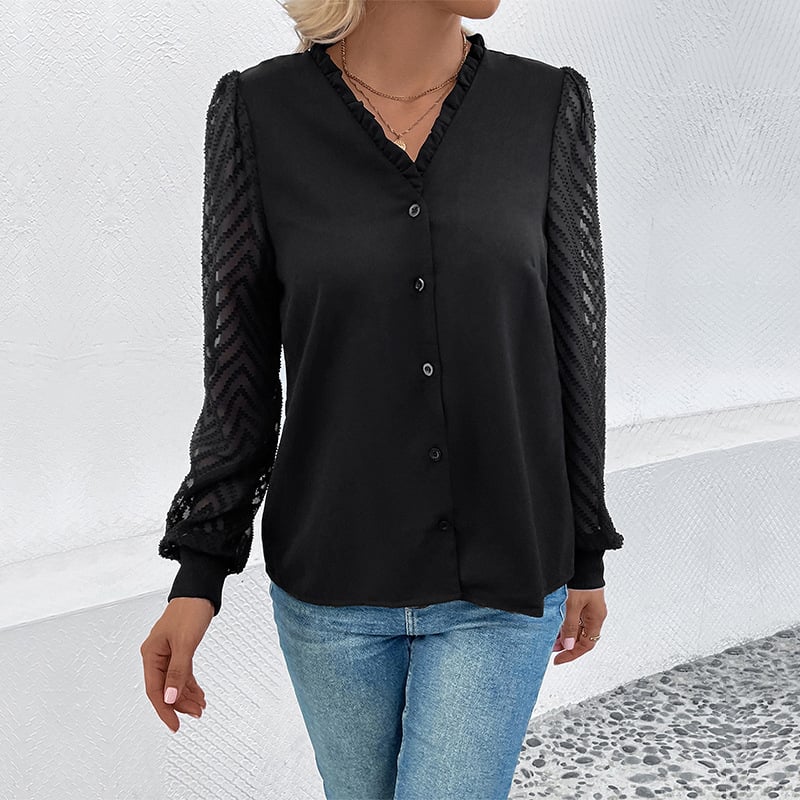 Donna con camicia nera elegante, maniche in pizzo trasparente, abbinata a jeans blu. Moda femminile, abbigliamento casual chic.
