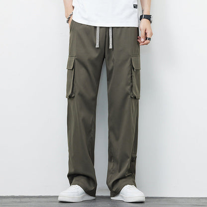 Pantaloni cargo uomo verde oliva, tasche laterali, stile casual, abbinati a scarpe bianche e t-shirt bianca. Moda maschile contemporanea.