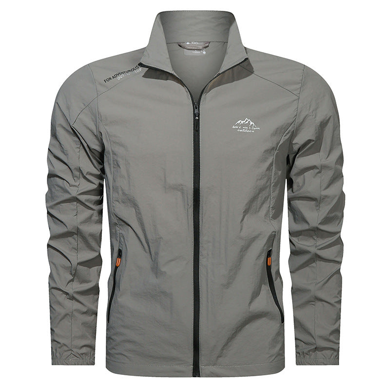 Giacca a vento grigia da uomo, leggera e impermeabile, con zip frontale e tasche laterali. Ideale per escursioni e attività outdoor.