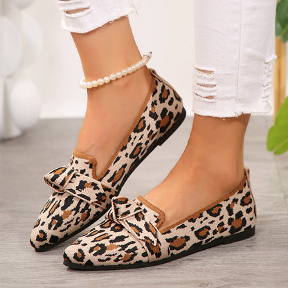 Scarpe mocassini donna leopardate con fiocco, indossate con jeans bianchi strappati. Moda calzature eleganti, stile casual chic.
