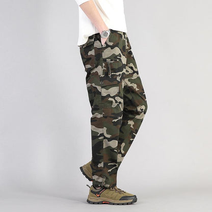 Pantaloni cargo mimetici uomo, stile militare, tasche multiple, abbinati a scarpe trekking marroni, moda casual outdoor.