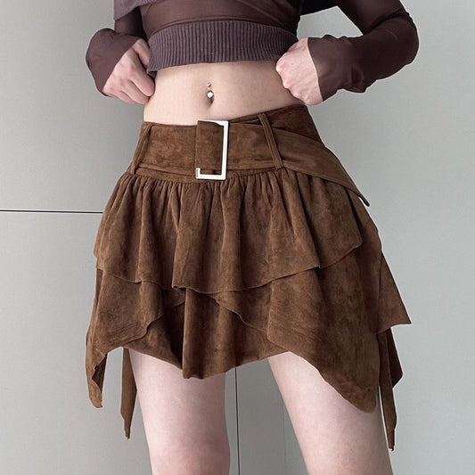 Gonna asimmetrica marrone in pelle scamosciata con cintura, indossata da una donna. Moda autunnale, abbigliamento femminile trendy.