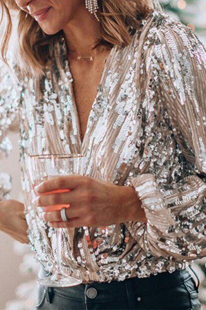 Donna con camicia di paillettes argentate, tiene un bicchiere in mano. Moda elegante, abbigliamento da festa, stile glamour.