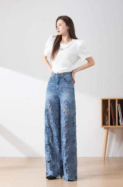 Donna in posa indossa jeans a zampa con dettagli in pizzo e maglietta bianca. Moda femminile, abbigliamento casual elegante, tendenze 2023.