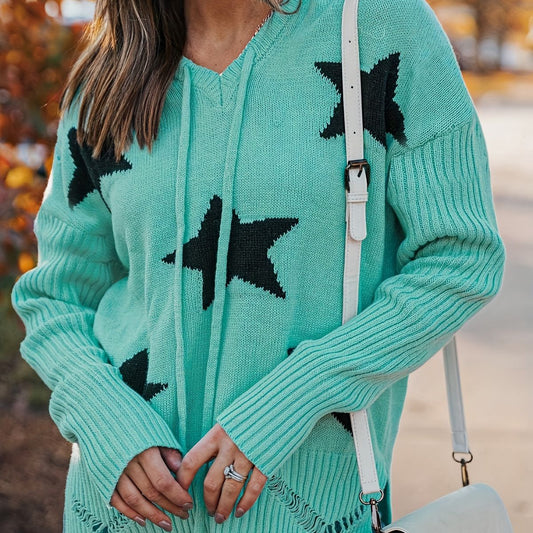 Donna con maglione verde acqua con stelle nere, borsa a tracolla bianca, sfondo autunnale. Moda autunno, abbigliamento casual chic.
