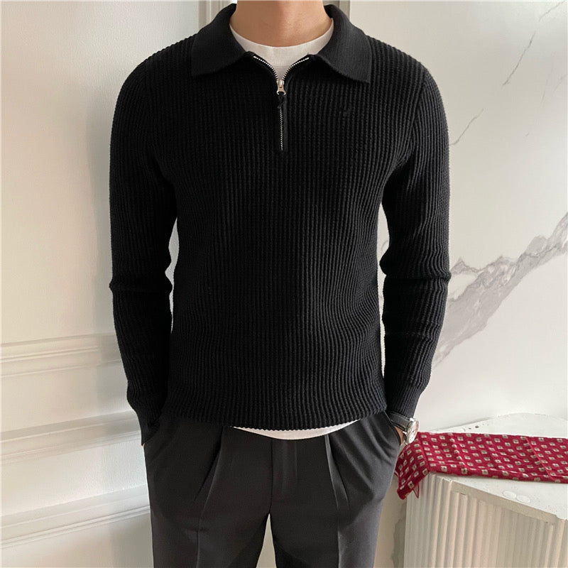 Uomo con maglione nero a coste con zip, camicia bianca sotto, pantaloni grigi. Stile casual elegante, moda uomo autunno inverno.
