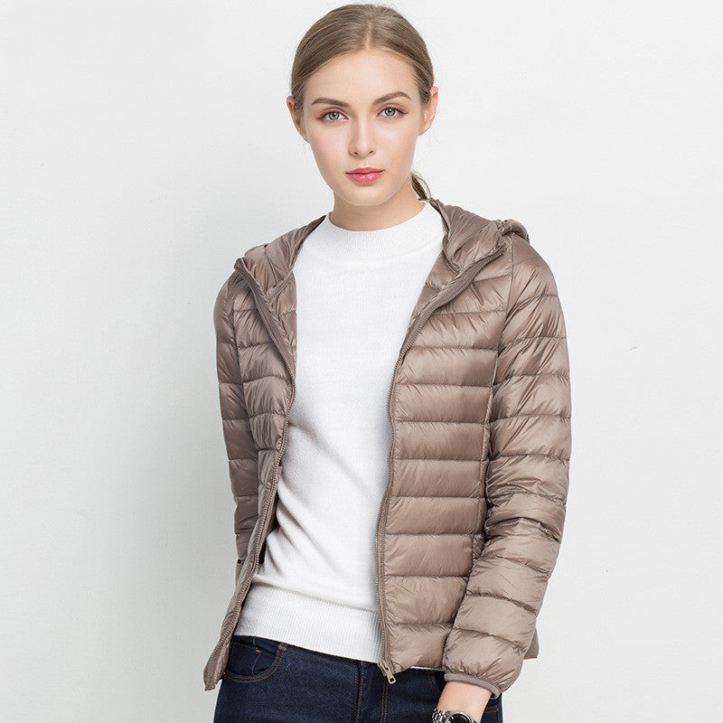 Giacca piumino donna beige, leggera e trapuntata, con cappuccio. Moda autunno-inverno, abbigliamento casual, stile moderno ed elegante.