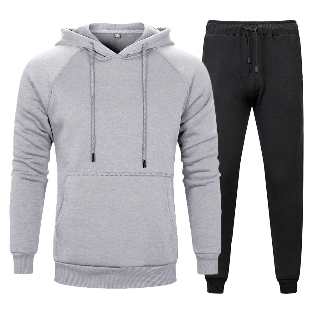 Set tuta sportiva uomo: felpa grigia con cappuccio e pantaloni neri. Abbigliamento casual, comodo e moderno per attività sportive e tempo libero.