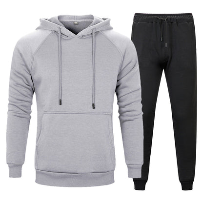 Set tuta sportiva uomo: felpa grigia con cappuccio e pantaloni neri. Abbigliamento casual, comodo e moderno per attività sportive e tempo libero.