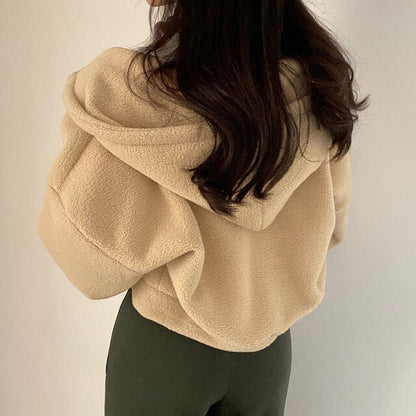 Donna con giacca in pile beige e cappuccio, vista posteriore. Moda autunnale, abbigliamento casual, tessuto morbido. Stile confortevole e caldo.