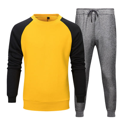 Felpa gialla con maniche nere e pantaloni grigi sportivi. Abbigliamento casual uomo, moda autunno, stile confortevole e moderno.