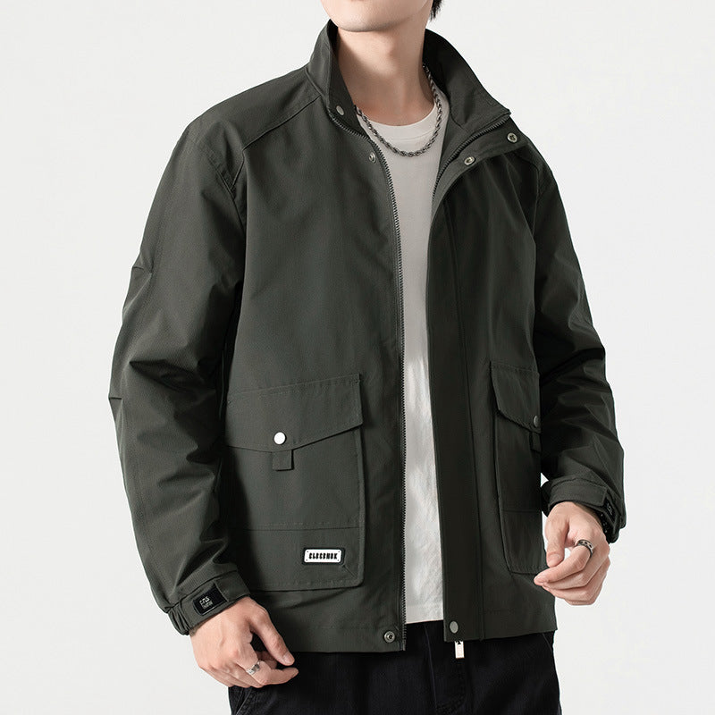 Giacca uomo verde scuro, stile casual, con tasche frontali e zip, indossata su maglietta bianca. Moda maschile autunnale, abbigliamento outdoor.