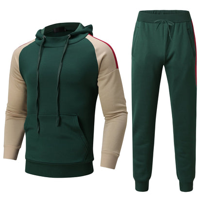 Tuta sportiva verde con felpa a cappuccio e pantaloni, maniche beige con strisce rosse. Abbigliamento casual uomo, moda autunno-inverno.